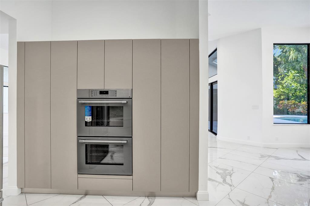 4701 Pine Tree Drive Boynton Beach, FL 33436 - Photo 21 of 76 a kitchen with cabinets and stainless steel appliances