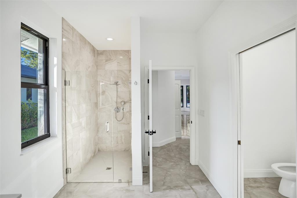 4701 Pine Tree Drive Boynton Beach, FL 33436 - Photo 36 of 76 a bathroom with a glass shower door