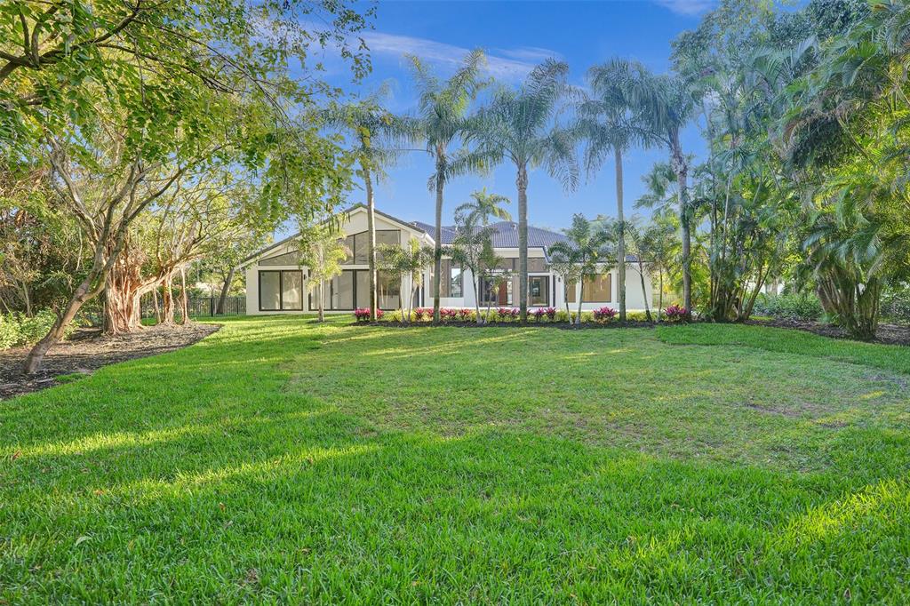 4701 Pine Tree Drive Boynton Beach, FL 33436 - Photo 60 of 76 a view of white house with a big yard and large trees