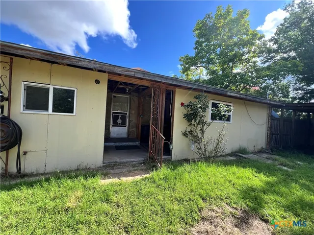 a view of backyard with barbeque grill and a tub