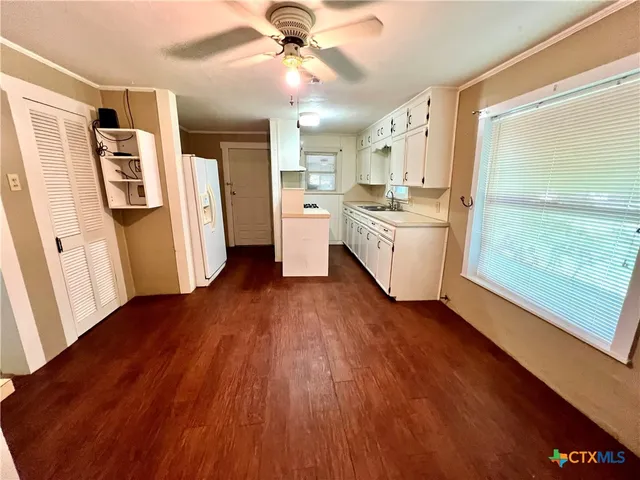 a kitchen with wooden floors and white cabinets