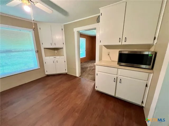 a kitchen with cabinets and wooden floor