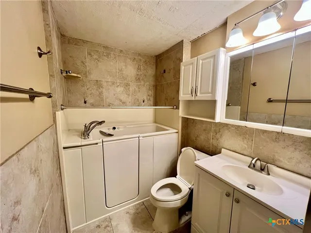 a bathroom with a sink and mirror with toilet