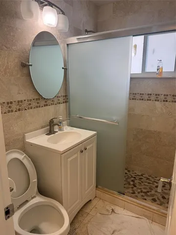 a bathroom with a sink toilet and shower