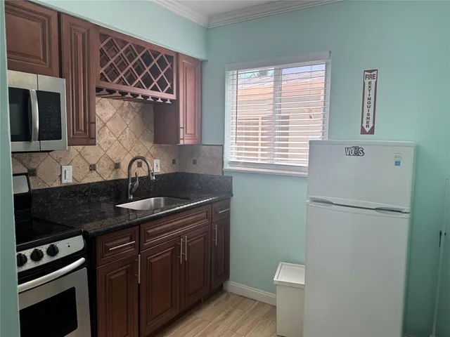 a kitchen with granite countertop cabinets stainless steel appliances and a window