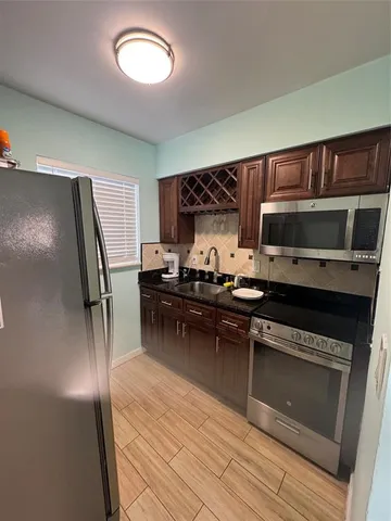 a kitchen with granite countertop a refrigerator stove and microwave