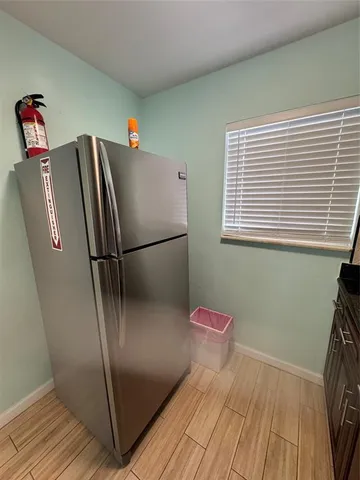 a kitchen with granite countertop a refrigerator and a sink