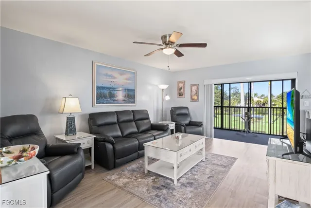 a living room with furniture floor to ceiling window and a flat screen tv
