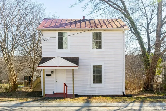 a view of a white house with a sink and yard