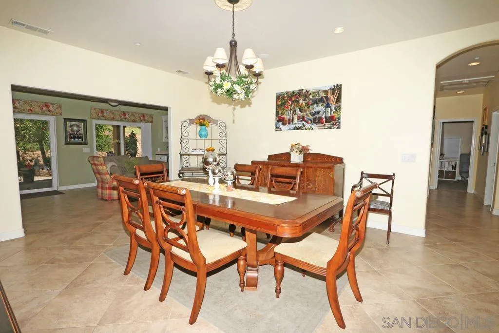 24568 Rutherford Road Ramona, CA 92065 - Photo 15 of 25 a dining room with furniture a chandelier and wooden floor