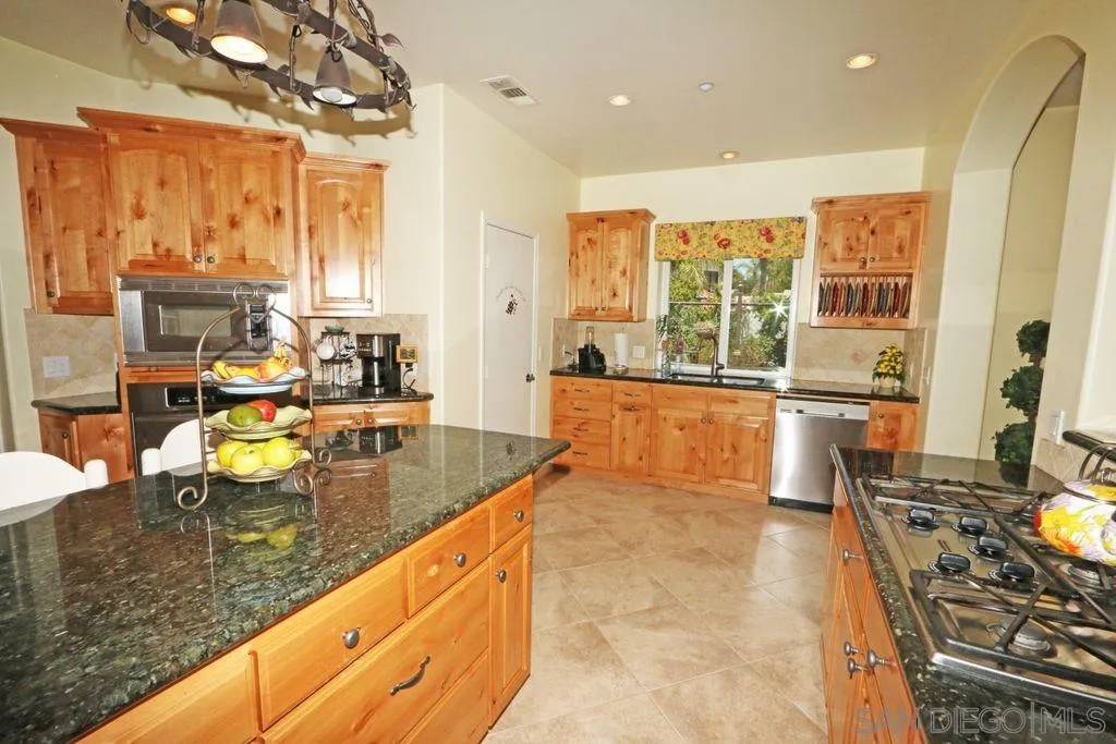 24568 Rutherford Road Ramona, CA 92065 - Photo 22 of 25 a large kitchen with kitchen island granite countertop a large window and a counter space