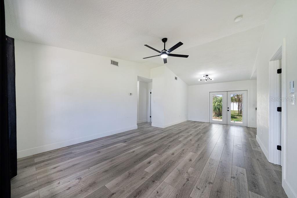682 Degroodt Road Southwest Palm Bay, FL 32908 - Photo 3 of 27 an empty room with wooden floor and windows