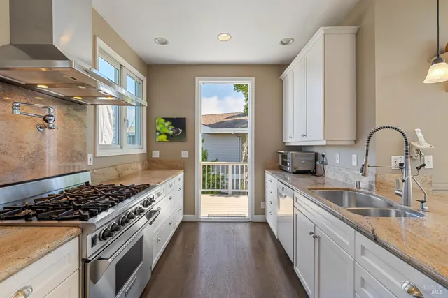 a kitchen with stainless steel appliances granite countertop a sink stove and cabinets