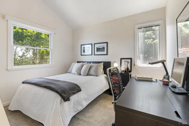 a bedroom with a bed and a painting on the wall