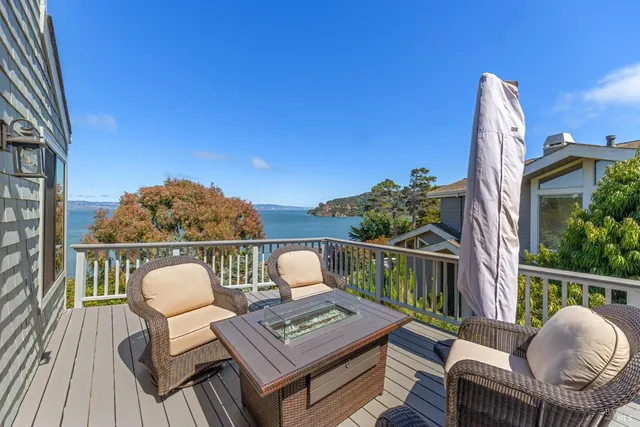 a view of a balcony with chairs and wooden floor