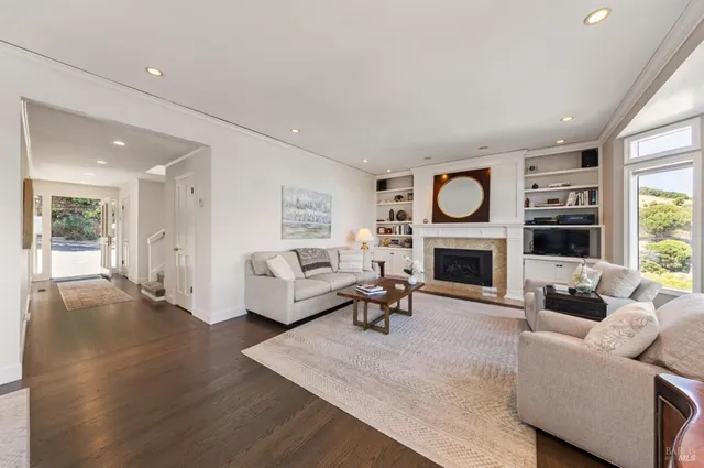 a living room with furniture a large window and a fireplace