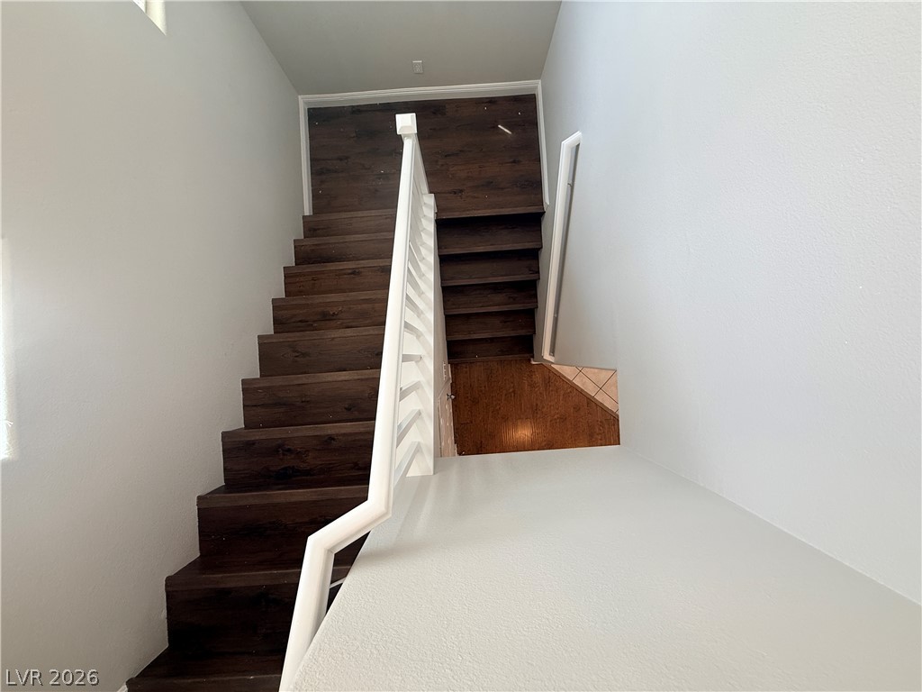 11953 Fairfax Ridge Street Las Vegas, NV 89183 - Photo 9 of 32 Dark wood steps and a crisp white banister create a welcoming entry.