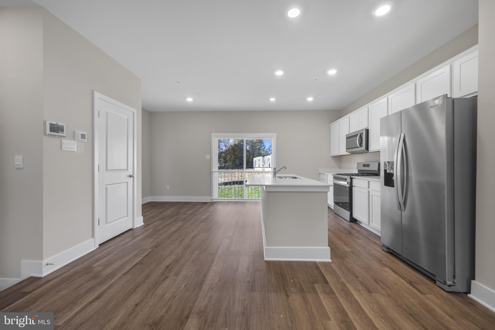 355 Hackley Drive Joppa, MD 21085 - Photo 14 of 38 a kitchen with stainless steel appliances a refrigerator and wooden floor