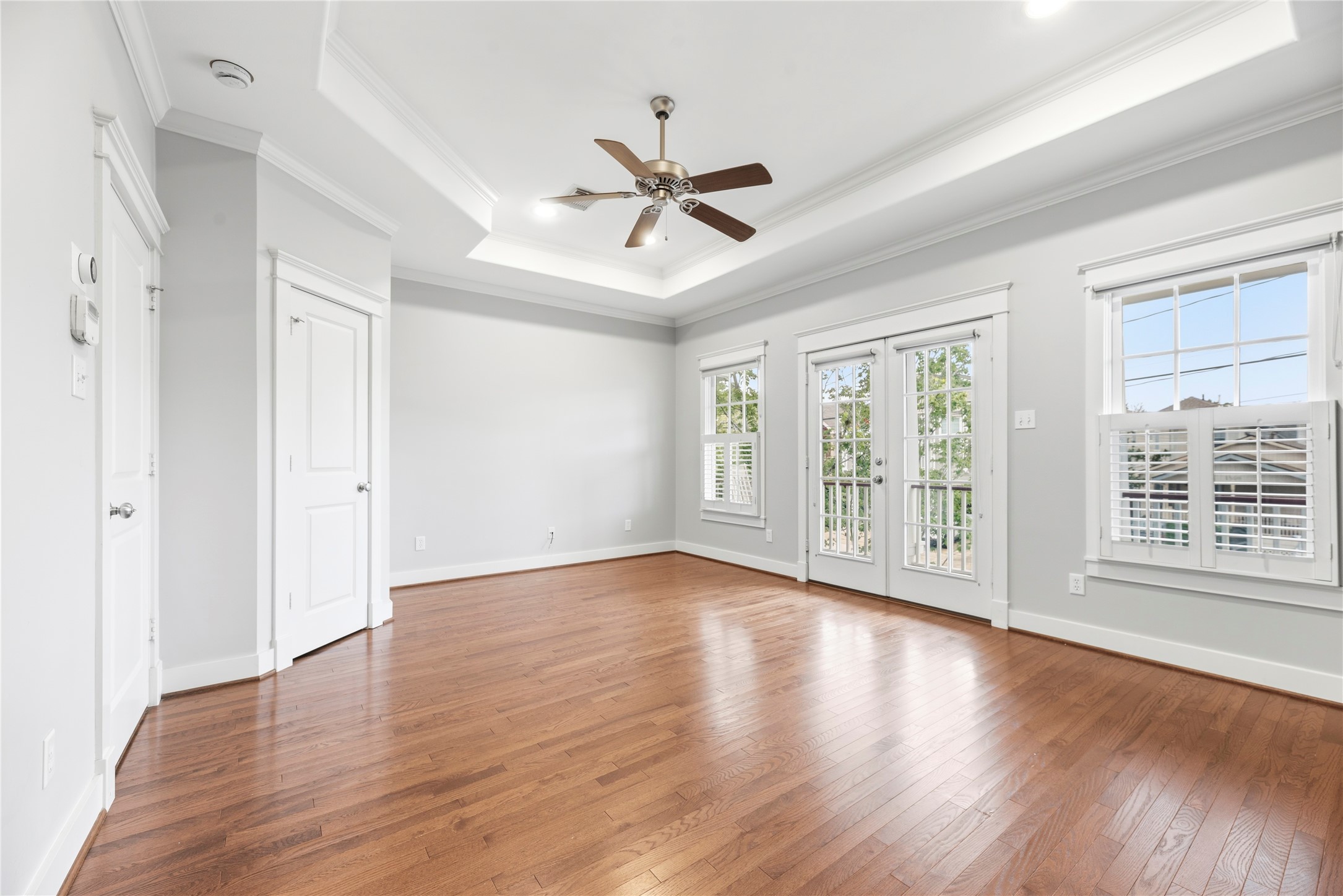 1505 Prince Street Houston, TX 77008 - Photo 17 of 39 The primary bedroom showcases gleaming hardwood floors and abundant natural light, with French doors leading to the balcony and dual walk-in closets.