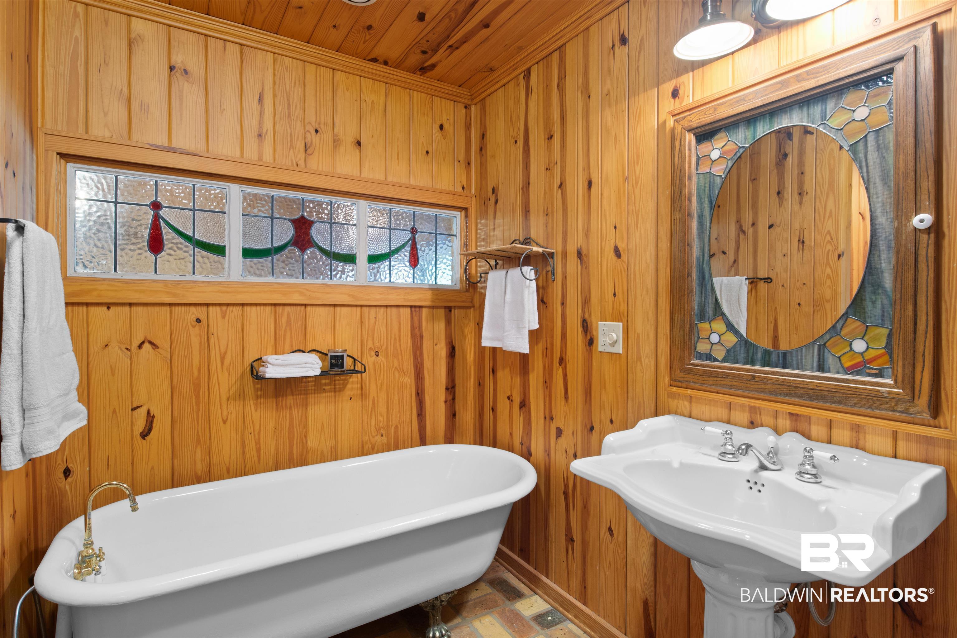 15100 Vasko Road Silverhill, AL 36576 - Photo 26 of 51 Bathroom featuring wood ceiling, crown molding, a bathtub, and wooden walls