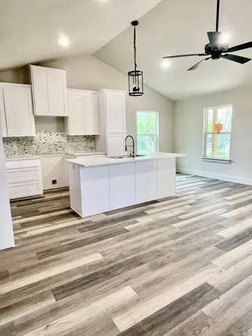 a view of kitchen with granite countertop stove top oven and cabinets