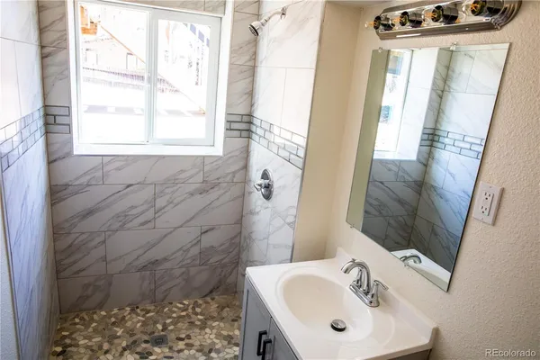 a bathroom with a sink a mirror and a shower