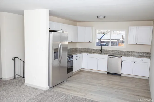 a kitchen with a refrigerator sink and cabinets
