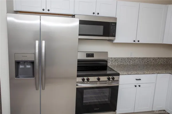 a kitchen with stainless steel appliances white cabinets and a stove