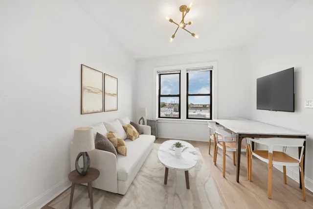 a living room with furniture a flat screen tv and a window