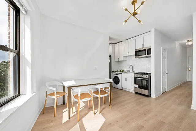 a kitchen with table chairs refrigerator and microwave