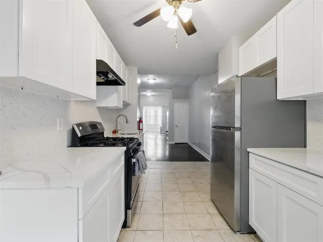 a kitchen with stainless steel appliances granite countertop a sink a stove and a refrigerator