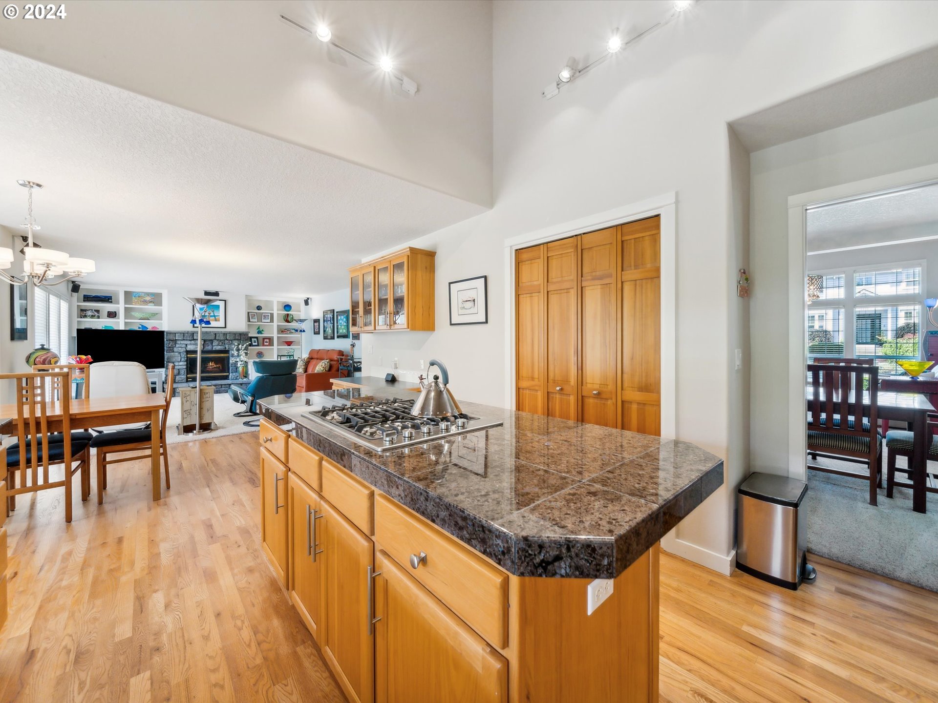 16368 Northwest Graf Street Portland, OR 97229 - Photo 20 of 46 a kitchen with stainless steel appliances granite countertop a stove top oven a dining table and chairs with wooden floor