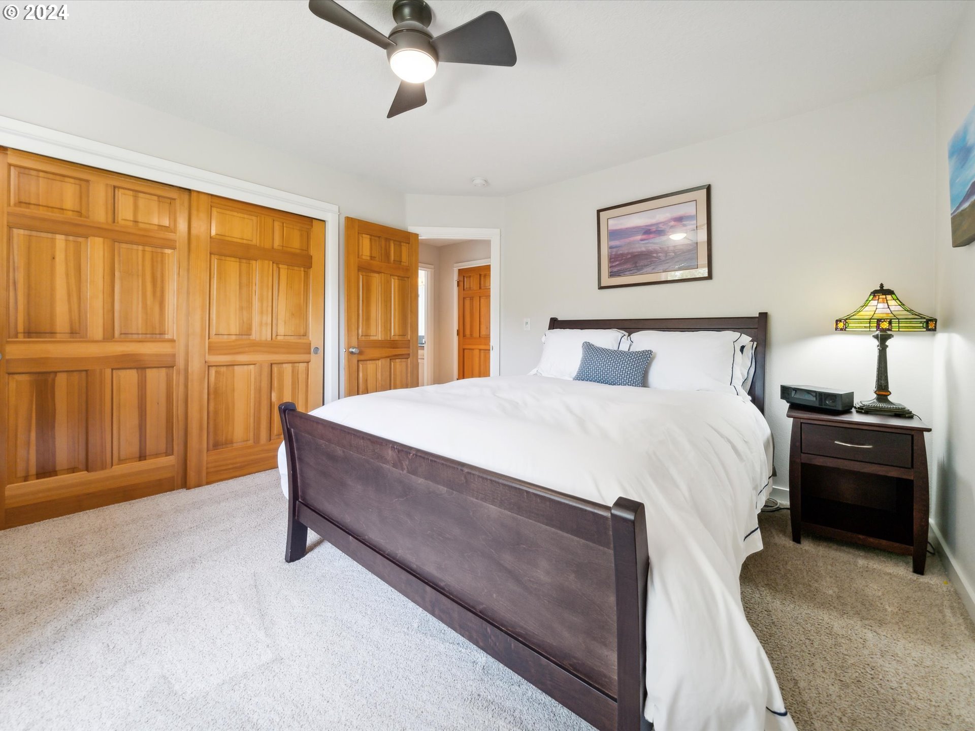 16368 Northwest Graf Street Portland, OR 97229 - Photo 31 of 46 a spacious bedroom with a bed and a chandelier