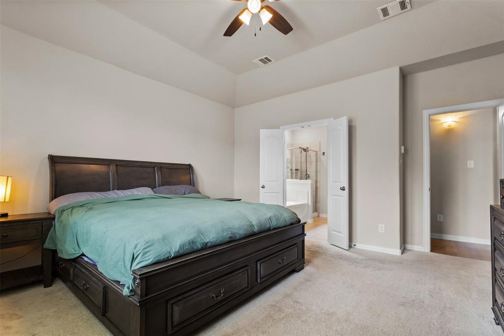 2304 Ravensway Road Crandall, TX 75114 - Photo 15 of 22 a bedroom with a bed and a chandelier