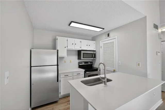 a kitchen with stainless steel appliances a refrigerator and a sink