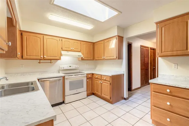 a kitchen with stainless steel appliances granite countertop a stove a sink and a refrigerator