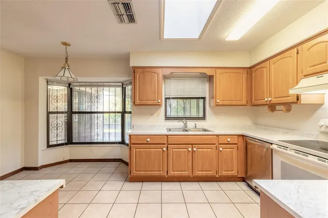 a kitchen with a sink window and cabinets