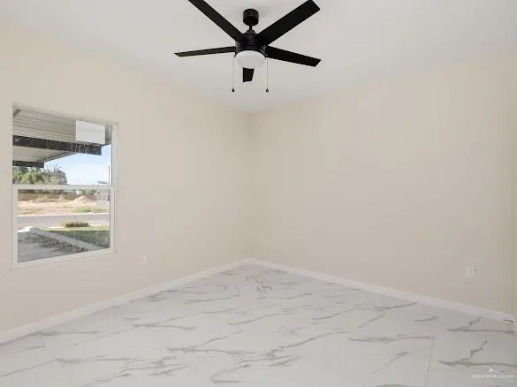 an empty room with a window and a ceiling fan