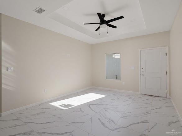 611 Mountain Road, Unit 5B Mission, TX 78573 - Photo 2 of 17 Spacious room featuring large format tile flooring, a tray ceiling with a ceiling fan, and neutral wall paint