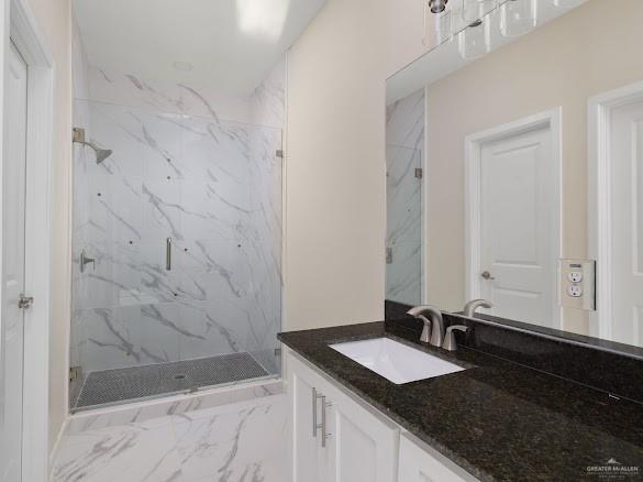 611 Mountain Road, Unit 5B Mission, TX 78573 - Photo 8 of 17 Contemporary bathroom featuring a spacious glass-enclosed shower with large format marble-look tile, a dark granite countertop vanity, and brushed nickel fixtures