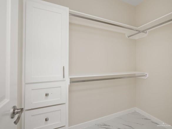 611 Mountain Road, Unit 5B Mission, TX 78573 - Photo 9 of 17 Custom closet system featuring white shaker cabinetry, brushed nickel hardware, and marble-look tile flooring