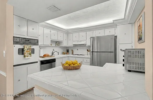 a kitchen with refrigerator and white cabinets