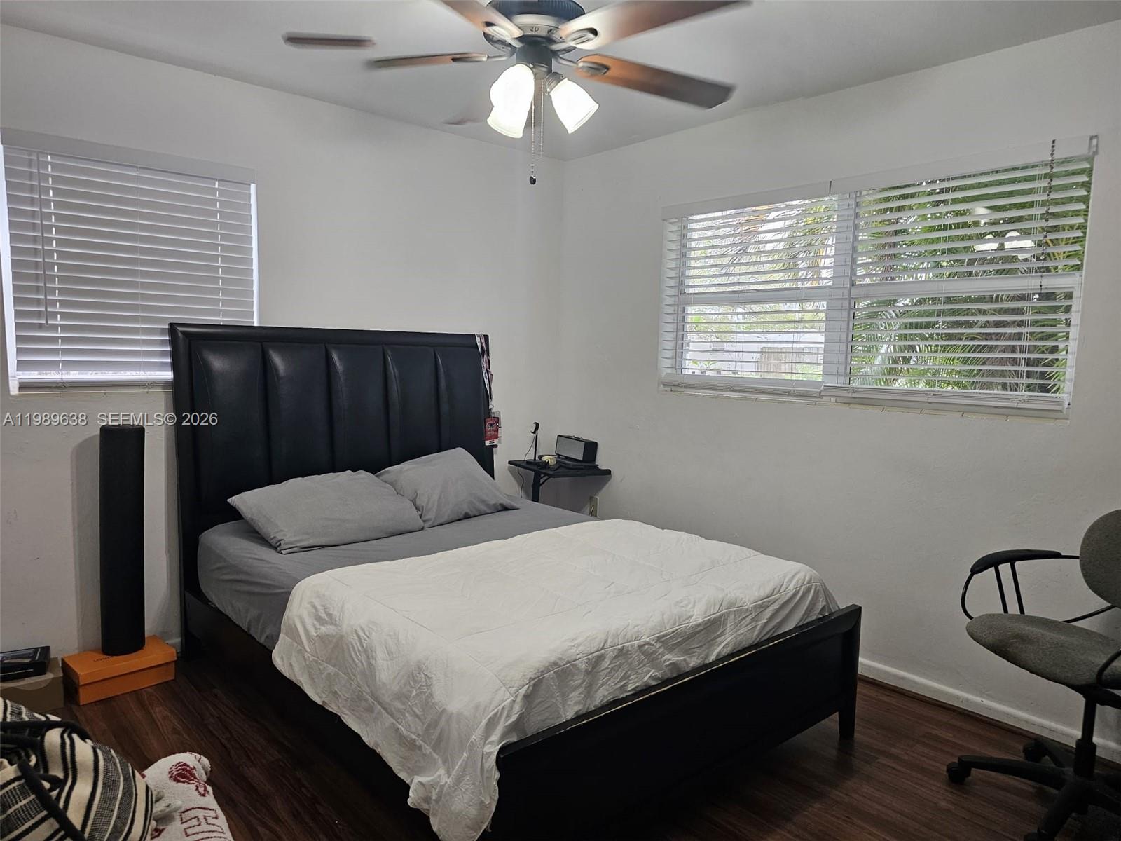 569 Tallulah Road Lake Worth, FL 33462 - Photo 18 of 40 a bedroom with a bed and dresser with wooden floor