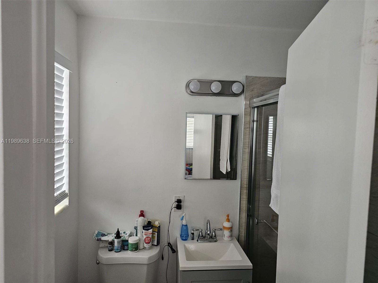 569 Tallulah Road Lake Worth, FL 33462 - Photo 21 of 40 a bathroom with a sink mirror and window