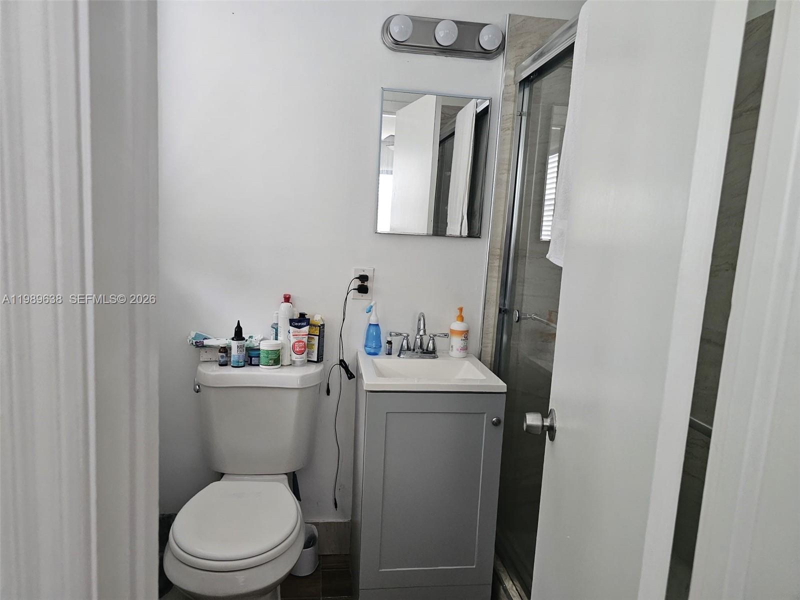 569 Tallulah Road Lake Worth, FL 33462 - Photo 22 of 40 a bathroom with a toilet a sink and a mirror
