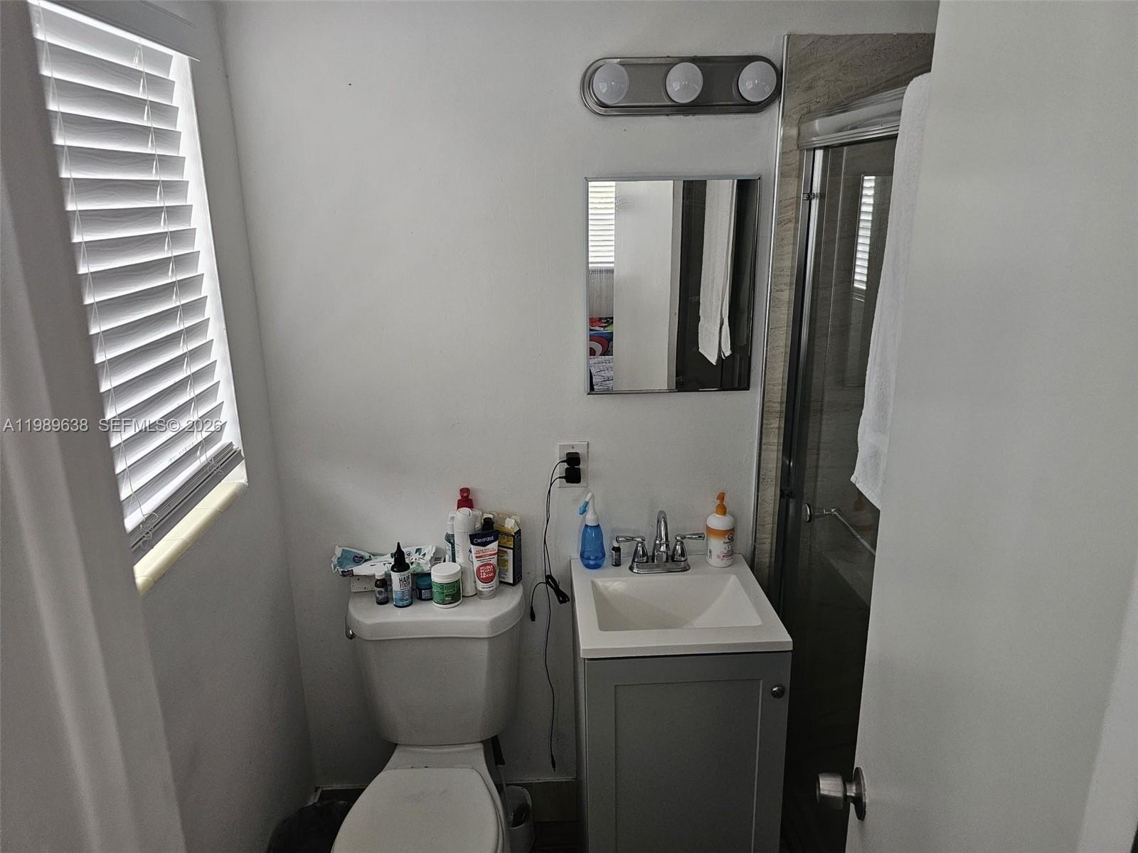 569 Tallulah Road Lake Worth, FL 33462 - Photo 23 of 40 a bathroom with a toilet sink and mirror