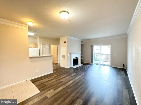 a view of empty room with wooden floor and fireplace