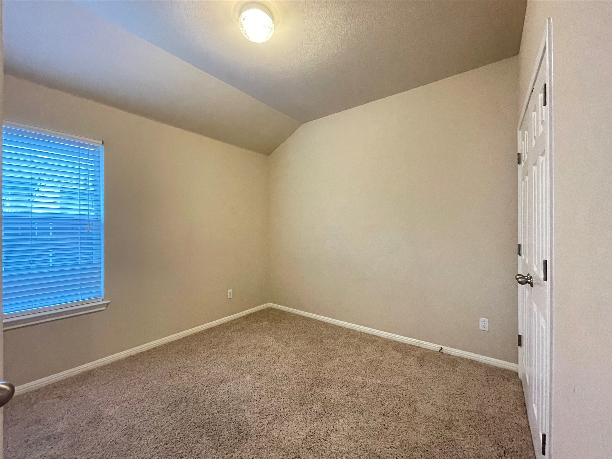 11713 Dunblane Way Austin, TX 78754 - Photo 17 of 22 Carpeted room with a vaulted ceiling, a single window, and neutral wall tones