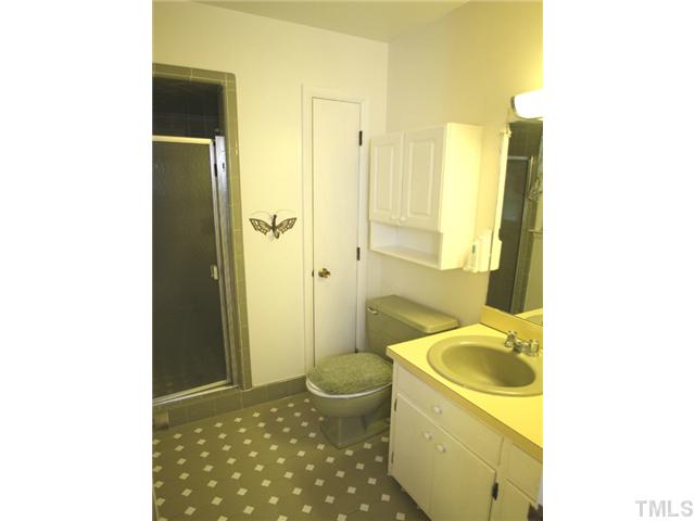 3817 Ingram Drive Raleigh, NC 27604 - Photo 8 of 13 a bathroom with a granite countertop sink a toilet and shower