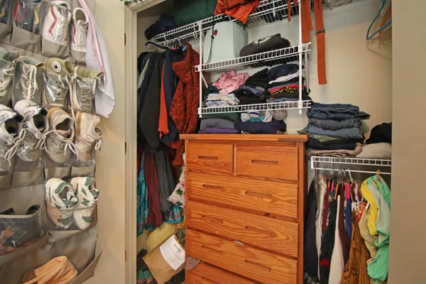 a view of walk in closet with clothes and shoes
